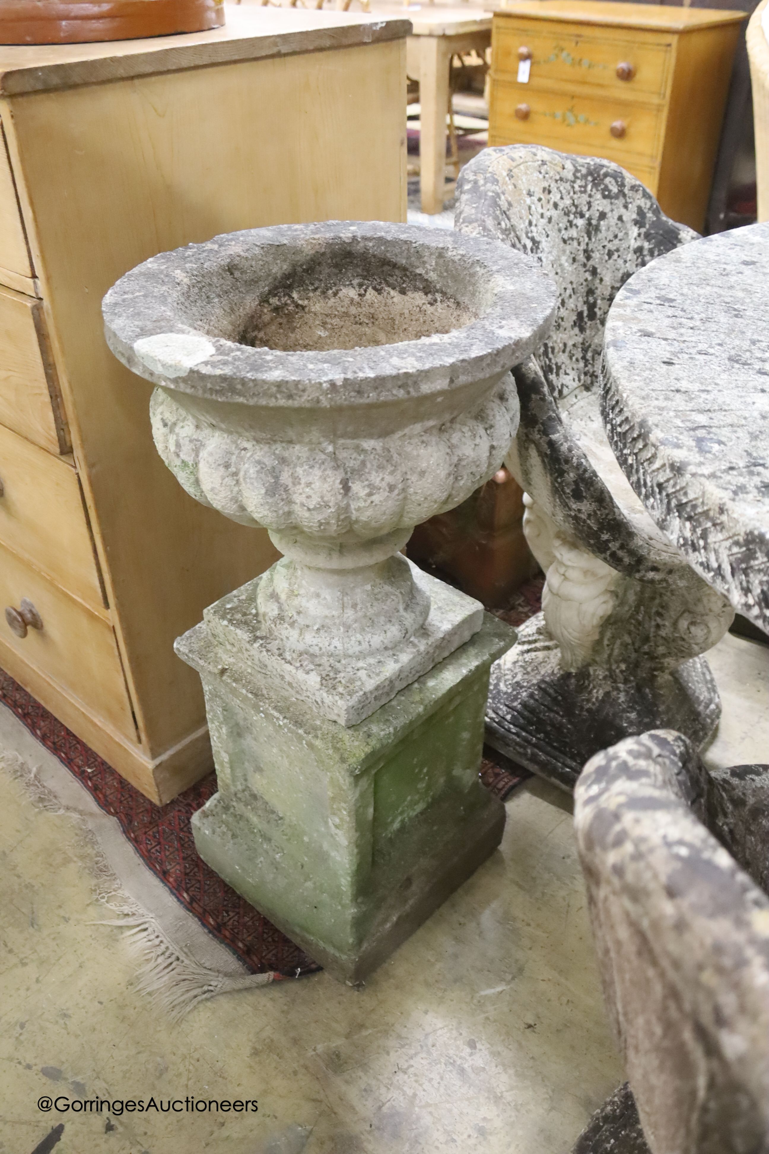 A circular reconstituted stone circular garden table, diameter 114cm, height 79cm and four matching chairs
